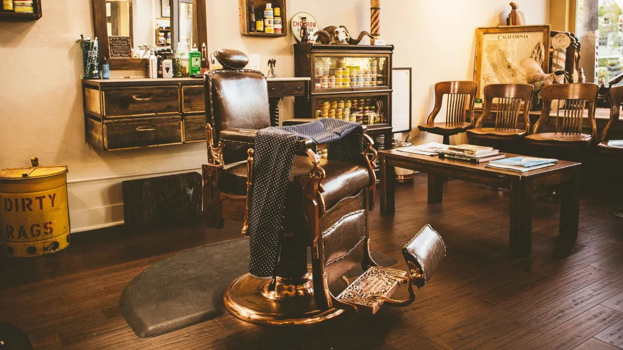 Interior of a classic barbershop with a vintage leather barber chair, wood cabinets, and mirrors