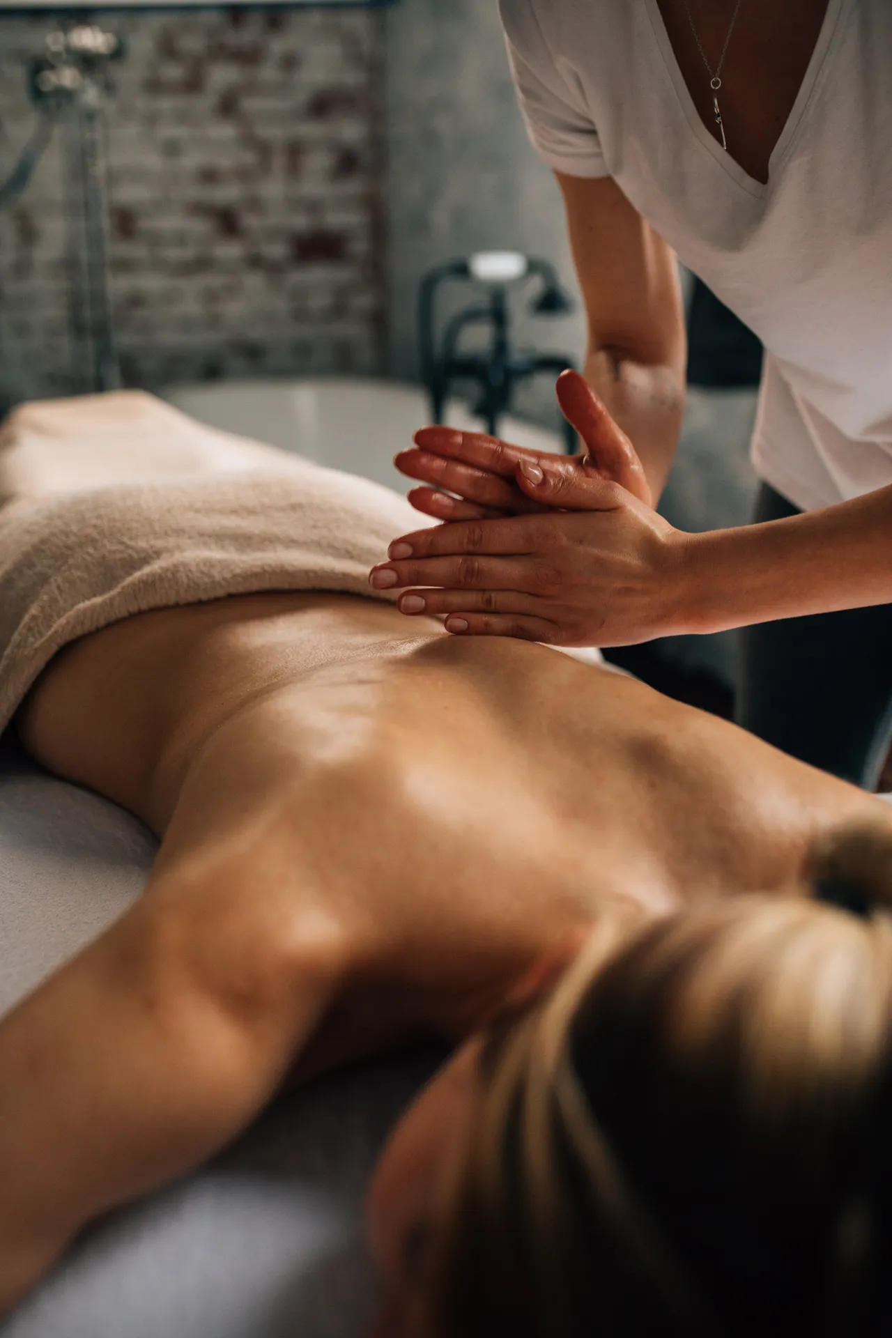 A masseuse providing a rejuvenating body massage in a calm modern spa treatment room