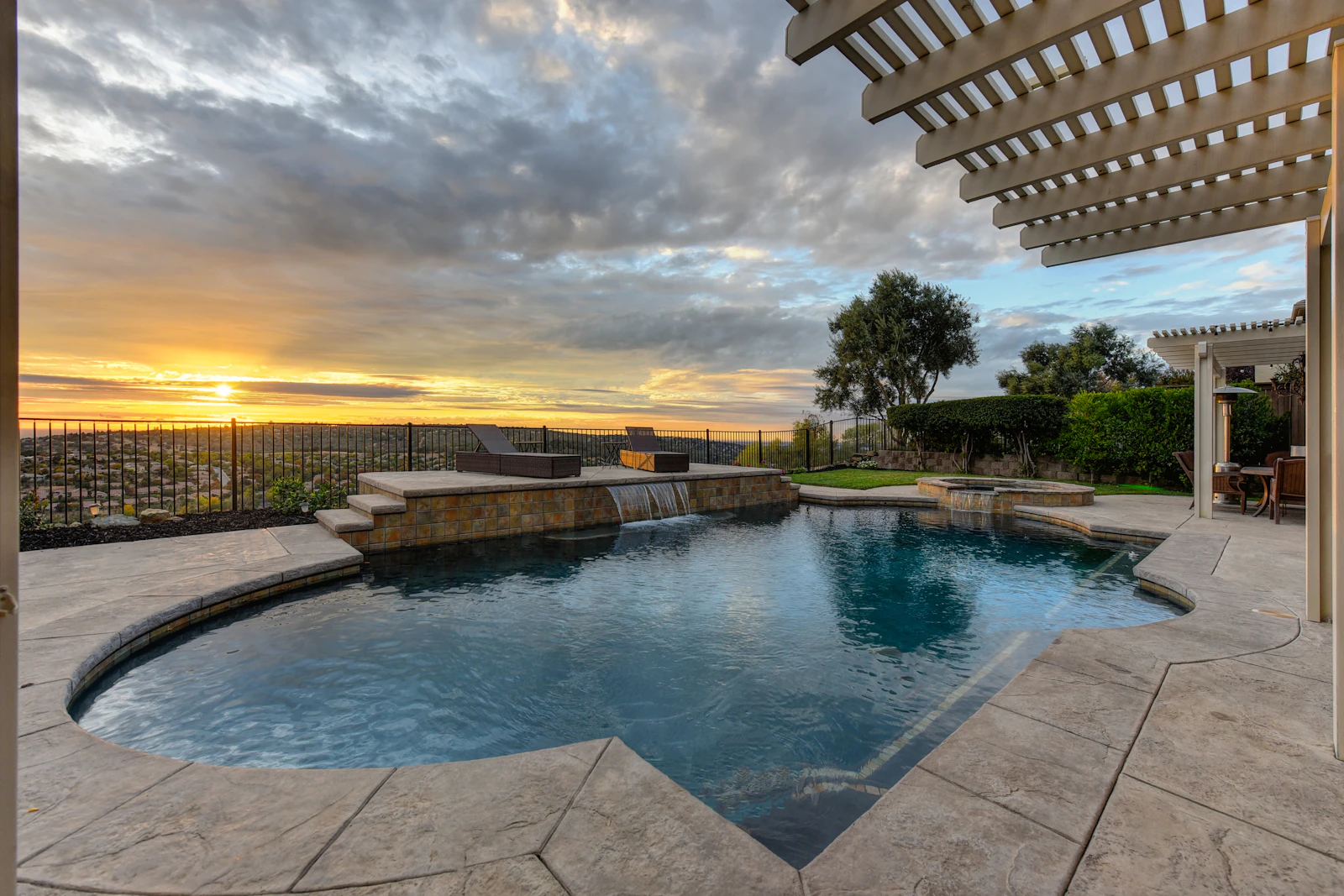 Stamped concrete patio and swimming pool at sunset